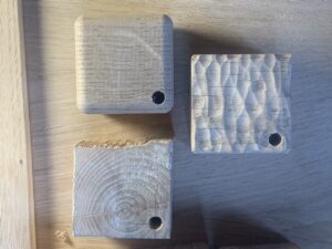 trois boîtes à dents vues de dessus. L'une d'entre elles est en orme, un bois assez grossier. Une autre est texturée à la gouge pour faire un motif de vagues.